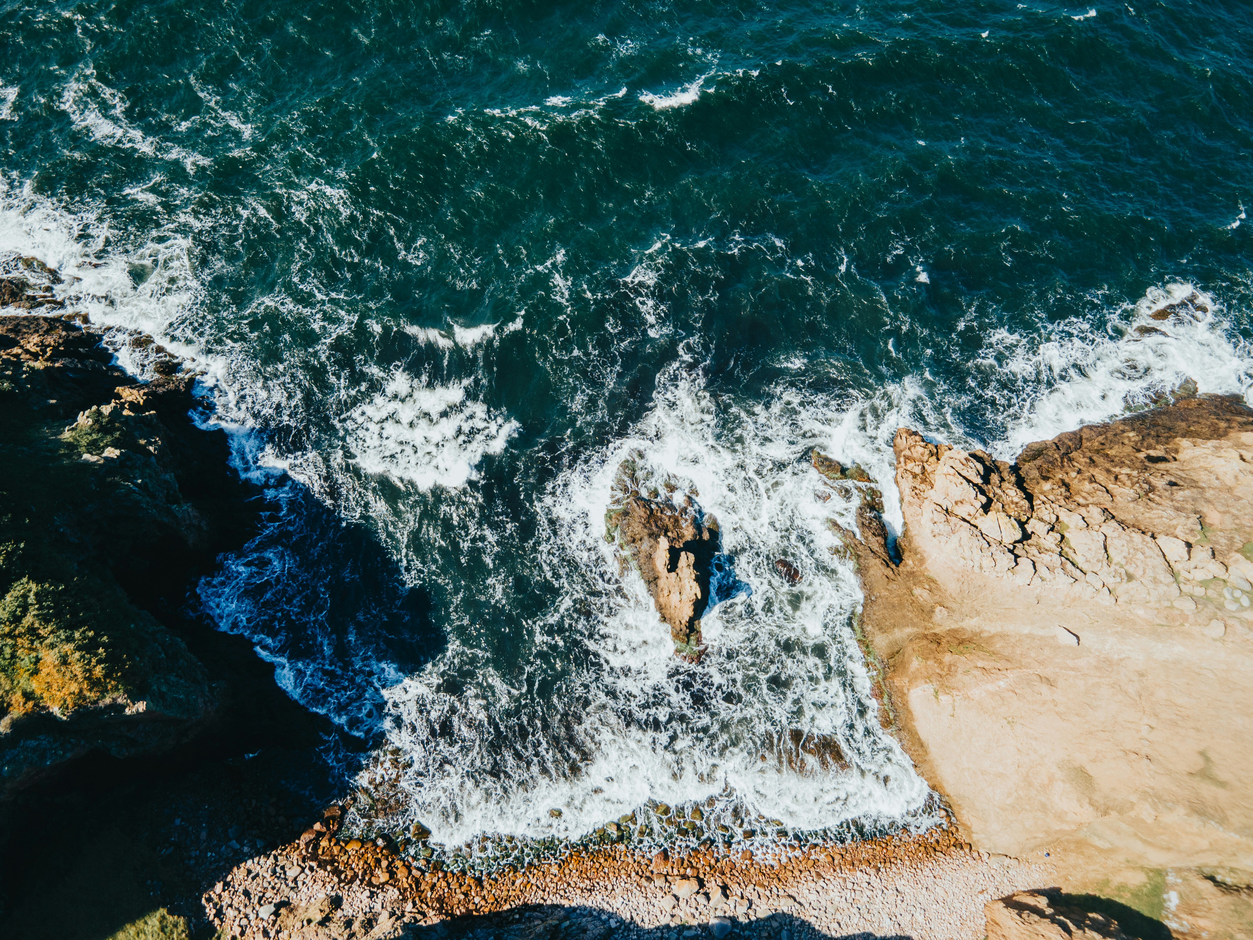 Dronefoto af klippekyst og bølger